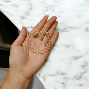 A lab-certified natural Sphatik crystal bracelet with polished 7mm beads, handcrafted and stretchable, resting on a soft white background