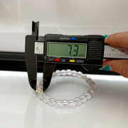 A lab-certified natural Sphatik crystal bracelet with polished 7mm beads, handcrafted and stretchable, resting on a soft white background