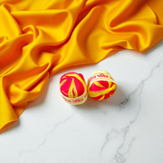 A pair of red and yellow sacred Moli Kalawa cotton threads neatly coiled, used in Hindu pooja rituals