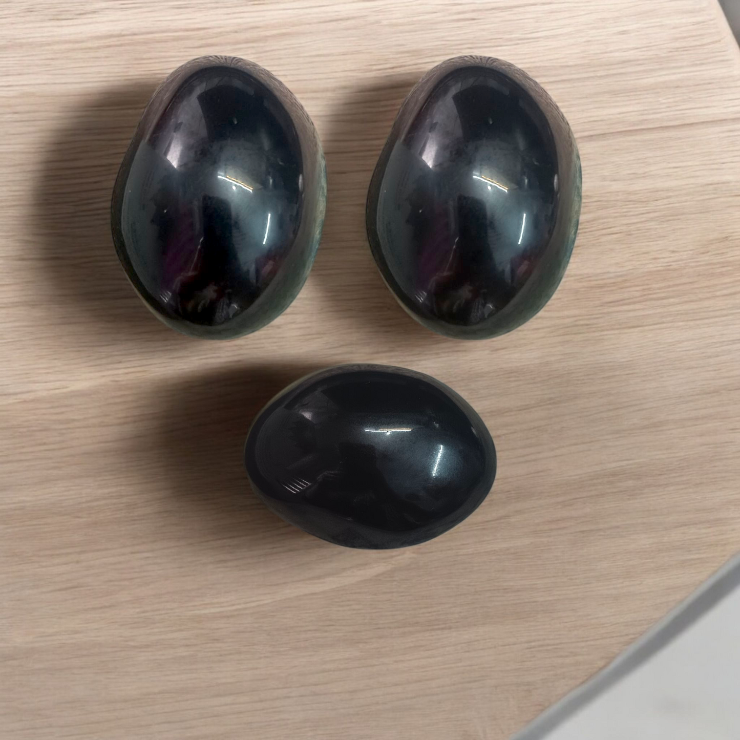 A polished black natural stone Shivling on a smooth base, used for spiritual worship, pooja, and rituals