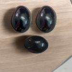 A polished black natural stone Shivling on a smooth base, used for spiritual worship, pooja, and rituals