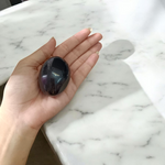 A polished black natural stone Shivling on a smooth base, used for spiritual worship, pooja, and rituals