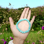 A polished natural blue chalcedony bracelet with 8mm round beads on an elastic stretchable cord, handcrafted for healing and style
