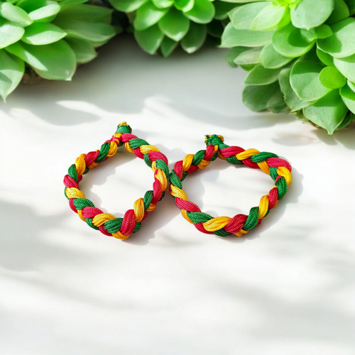 A set of two handmade Resham thread bracelets in vibrant colors, symbolizing good luck, positive energy, and success, displayed on a woman’s wrist