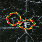 A set of two handmade Resham thread bracelets in vibrant colors, symbolizing good luck, positive energy, and success, displayed on a woman’s wrist