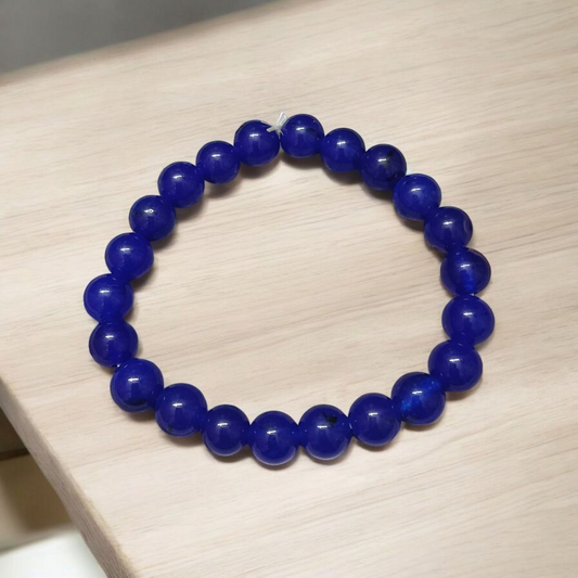 A stretchable Blue Onyx bracelet made of 8mm round beads, arranged neatly in a circular form on a clean white background