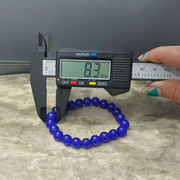 A stretchable Blue Onyx bracelet made of 8mm round beads, arranged neatly in a circular form on a clean white background