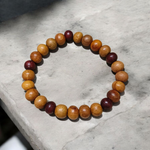 A stretchable bracelet made of alternating white and red 8mm sandalwood beads, displayed on a neutral background