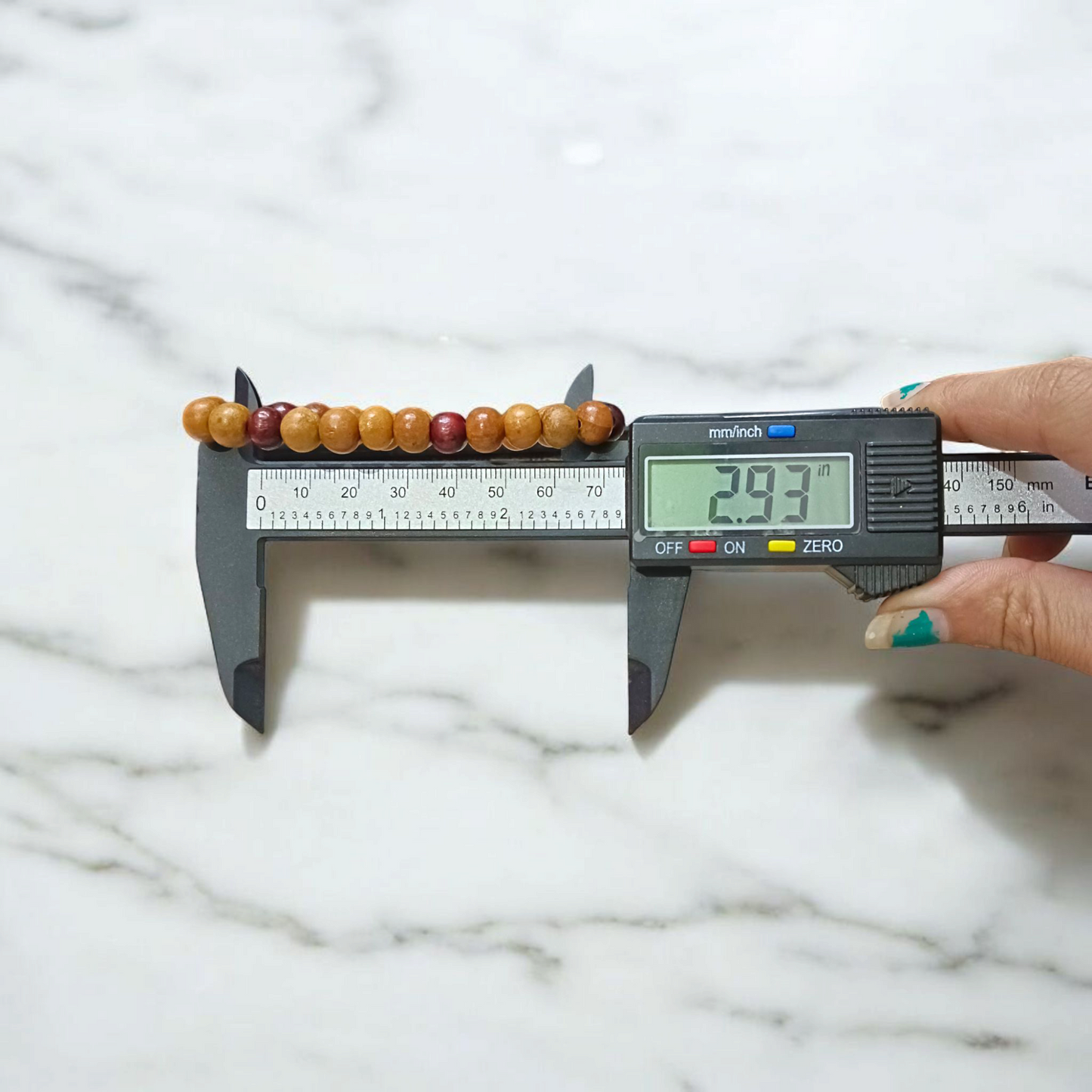 A stretchable bracelet made of alternating white and red 8mm sandalwood beads, displayed on a neutral background