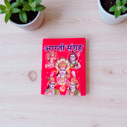 Aarti Sangrah Book in Hindi with traditional cover art, placed beside diya and idol in a temple setting