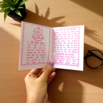 Aarti Sangrah Book in Hindi with traditional cover art, placed beside diya and idol in a temple setting