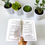 Bhajan Aradhana Hindi Book featuring colorful devotional cover, placed in a traditional worship setup with diya and flowers