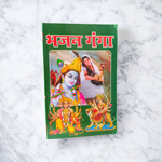 Bhajan Ganga Hindi Book with colorful spiritual design, placed on a wooden prayer stand with diya and flowers