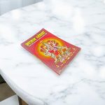 Bhajan Sandhya Hindi Book with vibrant devotional cover placed near diya and flowers in a worship setting