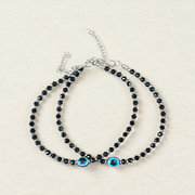 Black bead anklet for women with central evil eye charm, adjustable design for daily wear and spiritual protection by MALAWALA