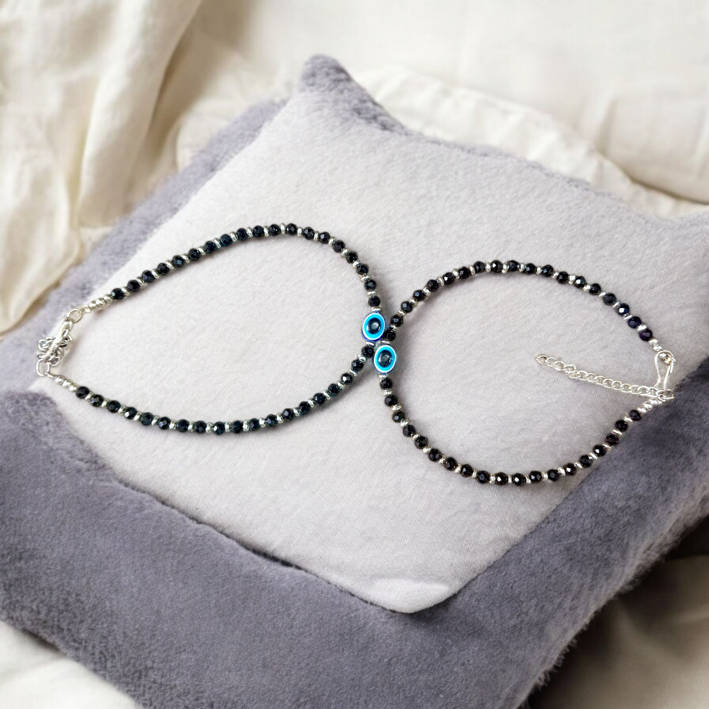 Black bead anklet for women with central evil eye charm, adjustable design for daily wear and spiritual protection by MALAWALA