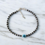 Black bead anklet for women with central evil eye charm, adjustable design for daily wear and spiritual protection by MALAWALA