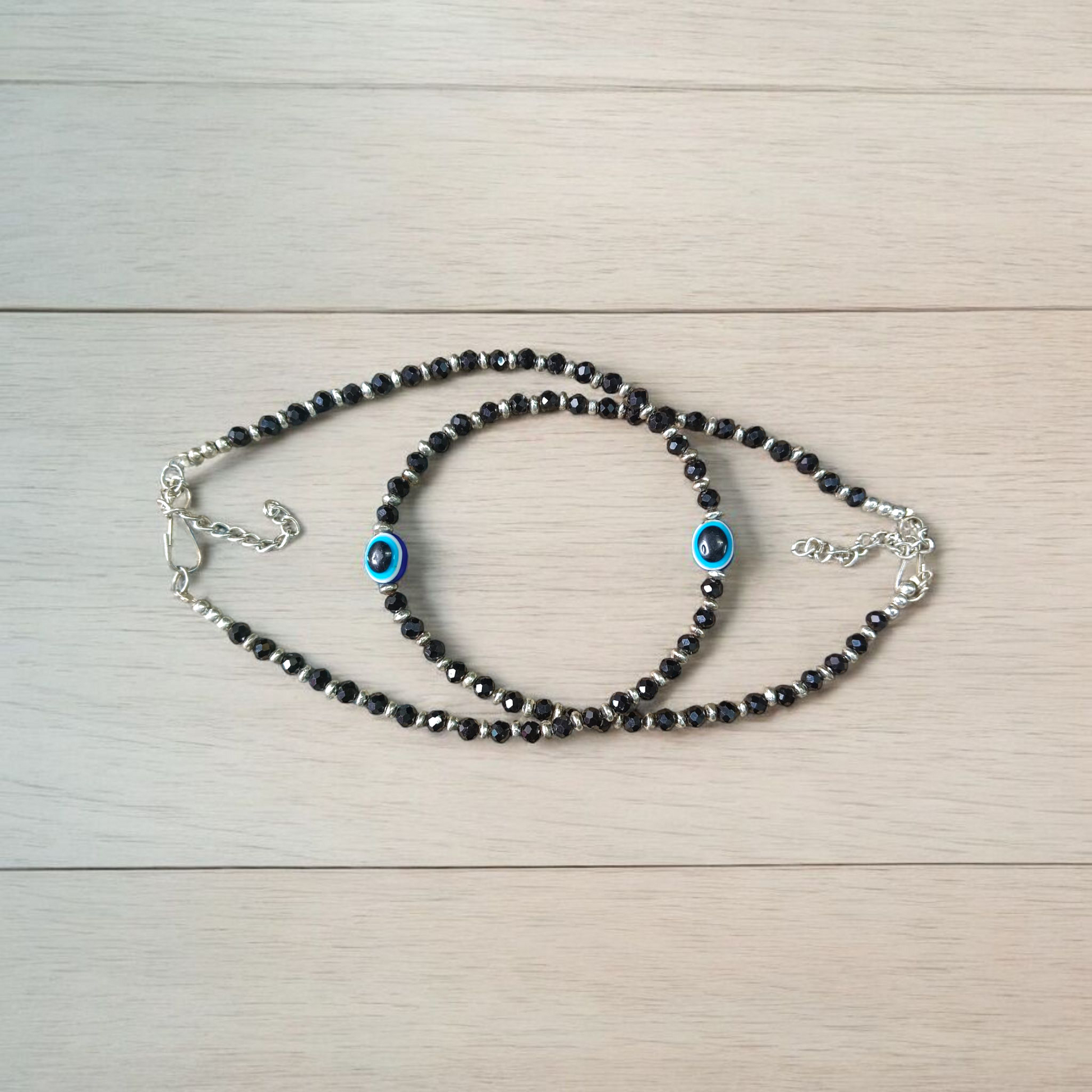 Black bead anklet for women with central evil eye charm, adjustable design for daily wear and spiritual protection by MALAWALA