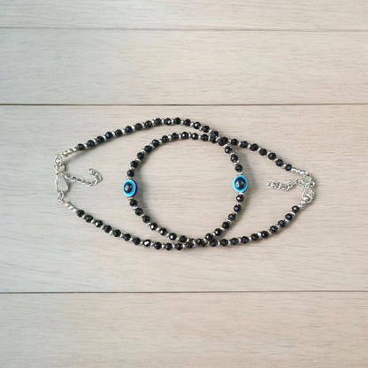 Black bead anklet for women with central evil eye charm, adjustable design for daily wear and spiritual protection by MALAWALA