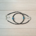 Black bead anklet for women with central evil eye charm, adjustable design for daily wear and spiritual protection by MALAWALA