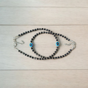 Black bead anklet for women with central evil eye charm, adjustable design for daily wear and spiritual protection by MALAWALA