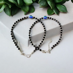 Black bead anklet for women with central evil eye charm, adjustable design for daily wear and spiritual protection by MALAWALA