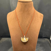 Close-up image of 1 Mukhi Rudraksha - One Face Kaju Rudraksha pendant with a lab certificate, highlighting its natural texture and shape.