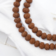 Close-up image of 7 Mukhi Rudraksha Mala 8MM beads showing natural texture and polished finish
