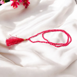 Close-up image of a Red Coral Mala with 3mm beads, showcasing the vibrant red color and traditional guru bead on a spiritual cloth