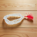 Close-up image of a premium 108+1 bead Sphatik (Crystal) Mala with 8MM beads, hand-knotted, radiant clear quartz beads, laid out on a white background
