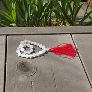 Close-up image of a premium 108+1 bead Sphatik (Crystal) Mala with 8MM beads, hand-knotted, radiant clear quartz beads, laid out on a white background
