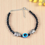 Close-up image of a stylish black bead anklet with a central evil eye charm, designed for girls by MALAWALA