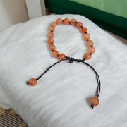 Close-up of Natural Gomed (Hessonite) 8MM bracelet with polished beads on elastic string