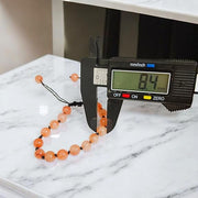 Close-up of Natural Gomed (Hessonite) 8MM bracelet with polished beads on elastic string