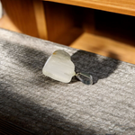 Close-up of a rough raw crystal quartz pendant with stainless steel chain, showcasing natural stone texture and clarity