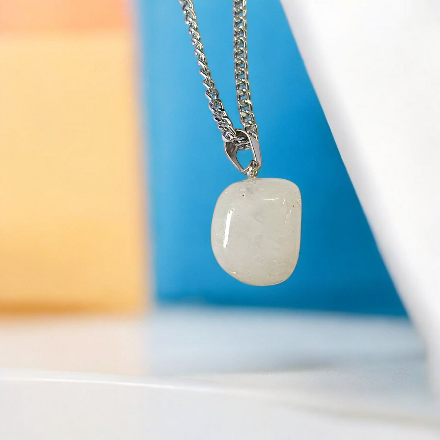 Close-up of a rough raw crystal quartz pendant with stainless steel chain, showcasing natural stone texture and clarity