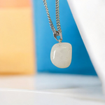 Close-up of a rough raw crystal quartz pendant with stainless steel chain, showcasing natural stone texture and clarity