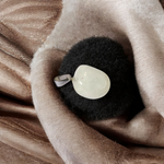 Close-up of a rough raw crystal quartz pendant with stainless steel chain, showcasing natural stone texture and clarity