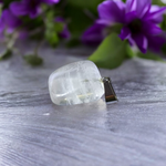 Close-up of a rough raw crystal quartz pendant with stainless steel chain, showcasing natural stone texture and clarity