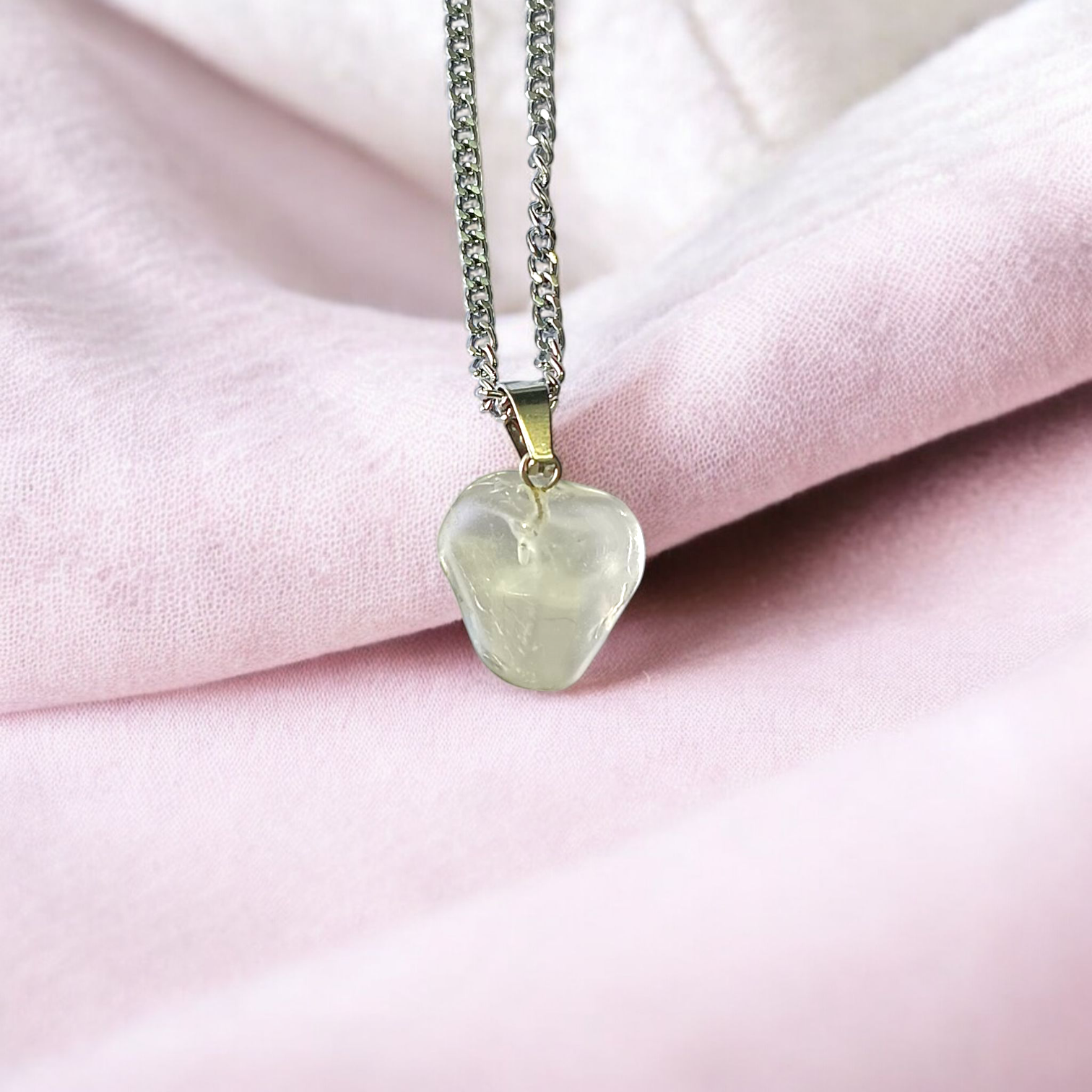 Close-up of a rough raw crystal quartz pendant with stainless steel chain, showcasing natural stone texture and clarity