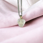 Close-up of a rough raw crystal quartz pendant with stainless steel chain, showcasing natural stone texture and clarity