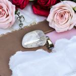 Close-up of a rough raw crystal quartz pendant with stainless steel chain, showcasing natural stone texture and clarity