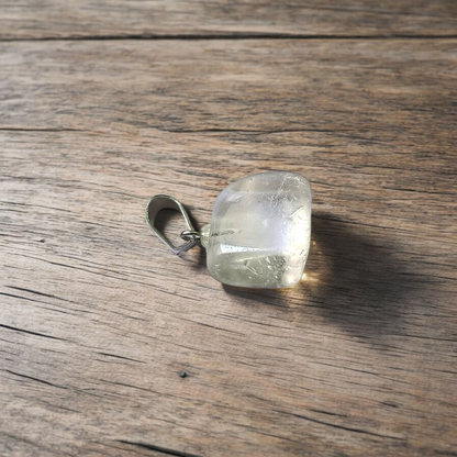 Close-up of a rough raw crystal quartz pendant with stainless steel chain, showcasing natural stone texture and clarity