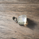 Close-up of a rough raw crystal quartz pendant with stainless steel chain, showcasing natural stone texture and clarity