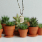 Close-up of a rough raw crystal quartz pendant with stainless steel chain, showcasing natural stone texture and clarity