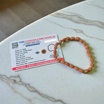 Close-up of an 8MM 2 Mukhi Rudraksha bracelet with uniform brown beads arranged in a stretchable loop on a white background