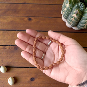 Close-up of an 8MM 2 Mukhi Rudraksha bracelet with uniform brown beads arranged in a stretchable loop on a white background