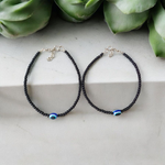 Elegant anklet with blue evil eye charm for girls and women, featuring adjustable chain and delicate bead detailing, designed for protection and style