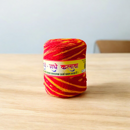Extra-large red and yellow twisted cotton Moli Kalawa thread rolled neatly, ideal for pooja and Raksha Bandhan rituals
