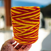 Extra large bundle of red Kalawa Moli thread, neatly rolled, with strands displayed beside for ceremonial use